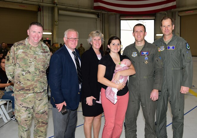 A group photo of a medal recipient and his family with 18th Air Force leadership.