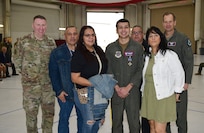 A group photo of a medal recipient and his family with 18th Air Force leadership.