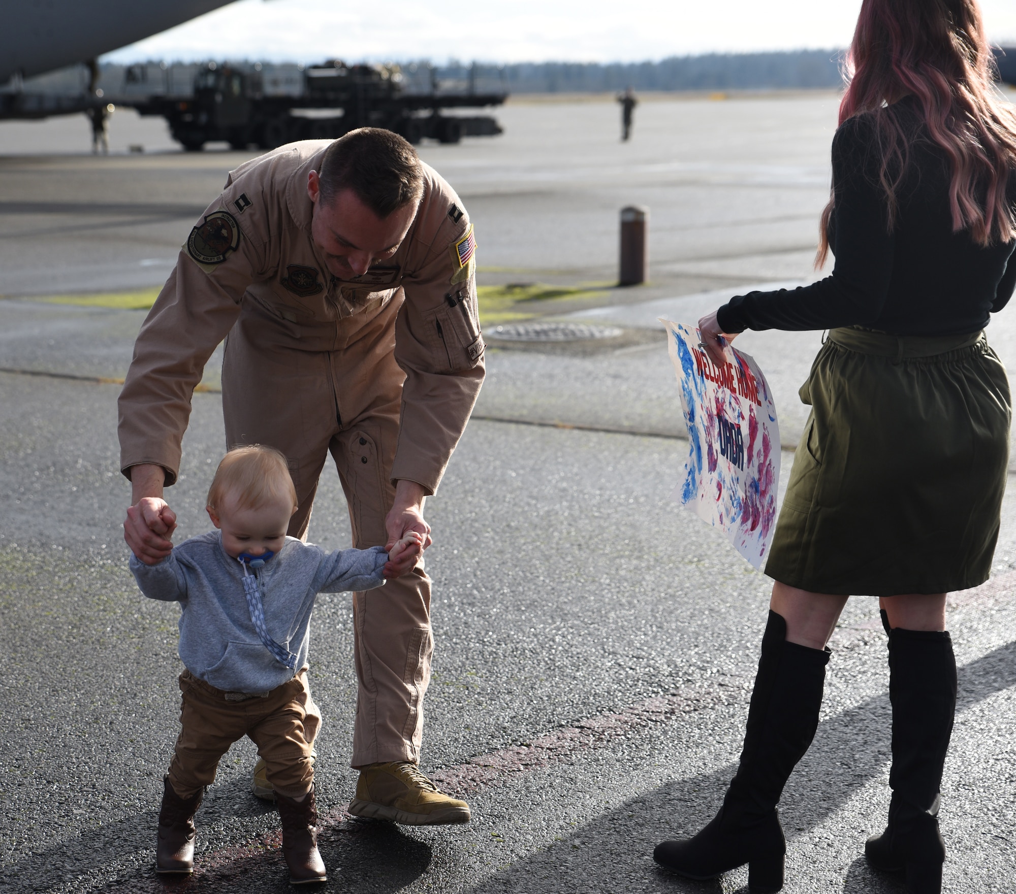 U.S. Air Force Capt. Dylan Juedeman, C-17 Globemaster lll instructor pilot with the 8th Airlift Squadron, reunites with his loved ones after returning from a deployment at Joint Base Lewis-McChord, Washington, Jan. 3, 2023. Juedeman was one of many deployed Airmen reuniting with friends and family. (U.S. Air Force photo by Airman Kylee Tyus)