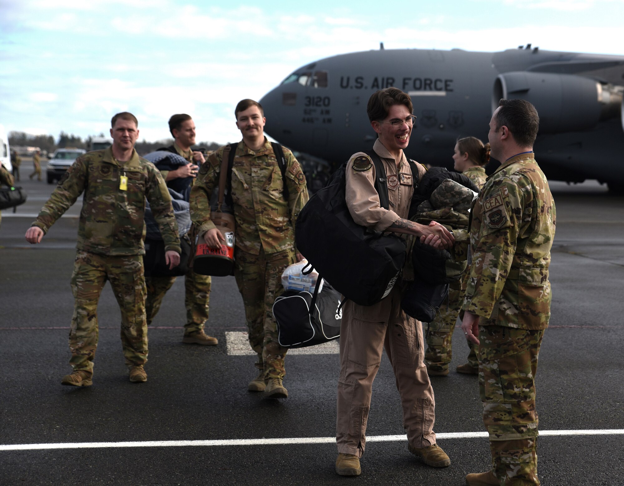 U.S. Airmen reunite with family and friends after returning from a deployment at Joint Base Lewis-McChord, Washington, Jan. 3, 2023. Nearly two-dozen Team McChord Airmen with the 8th Airlift Squadron reunited with their loved ones after being deployed for several months. (U.S. Air Force photo by Airman Kylee Tyus)