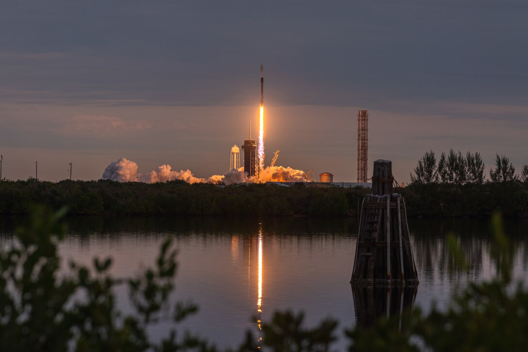 A rocket launches into space at twilight.