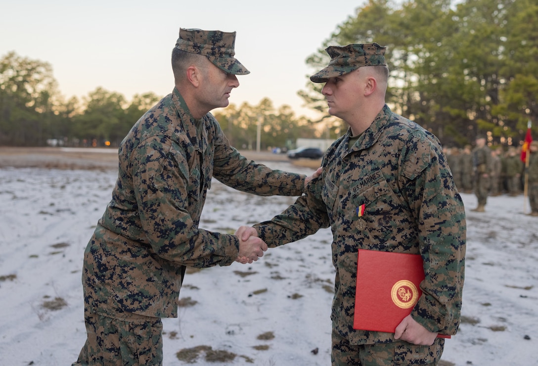 U.S. Marine Corps Sgt. Maj. Christopher J. Adams, 4th Marine Division Sergeant Major, congratulates Sgt. Joseph Howard, a Yonkers, New York native and an infantry mortarman with Weapons Company, 2nd Battalion, 25th Marine Regiment, 4th Marine Division, for being awarded with a Navy and Marine Corps Medal at McGuire Air Force Base, New Jersey, Dec. 9, 2022. The Navy and Marine Corps Medal is the highest non-combatant decoration awarded. On Dec 30, 2017, at the time a lance corporal, Howard witnessed a car collision between four vehicles. Victims were trapped in a vehicle that had flipped eight times over a distance of 300 feet. Howard extracted the two unconscious victims from the car that continued to leak fuel. As he moved the second victim to safety, the vehicle was engulfed in flames and exploded. He then reassessed their injuries and provided life-saving first aid until first responders arrived. By his bold initiative and unwavering dedication to duty, Lance Cpl. Howard reflected great credit upon himself and upheld the highest traditions of the Marine Corps and United States Naval Service.