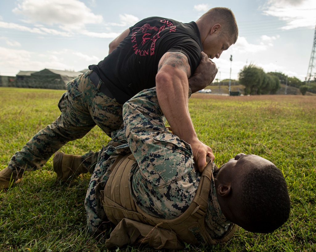 U.S. Marine 1st Sgt. Daniel Sandlin, a company first sergeant for Battalion Landing Team 3/5, 31st Marine Expeditionary Unit, grabs Cpl. Victor Obakpe, an engineer equipment mechanic with BLT 3/5, 31st MEU, during a Martial Arts Instructor Course at Camp Hansen, Okinawa, Japan, Nov. 4, 2021. The Martial Arts Instructor Course is designed to teach Marine Corps Martial Arts Program principles and combat conditioning to prepare Marines as MCMAP instructors. The 31st MEU, the Marine Corps' only continuously forward-deployed MEU, provides a flexible and lethal force ready to perform a wide range of military operations as the premier crisis response force in the Indo-Pacific region.
