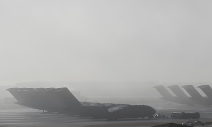 Several aircraft sit on a flightline.