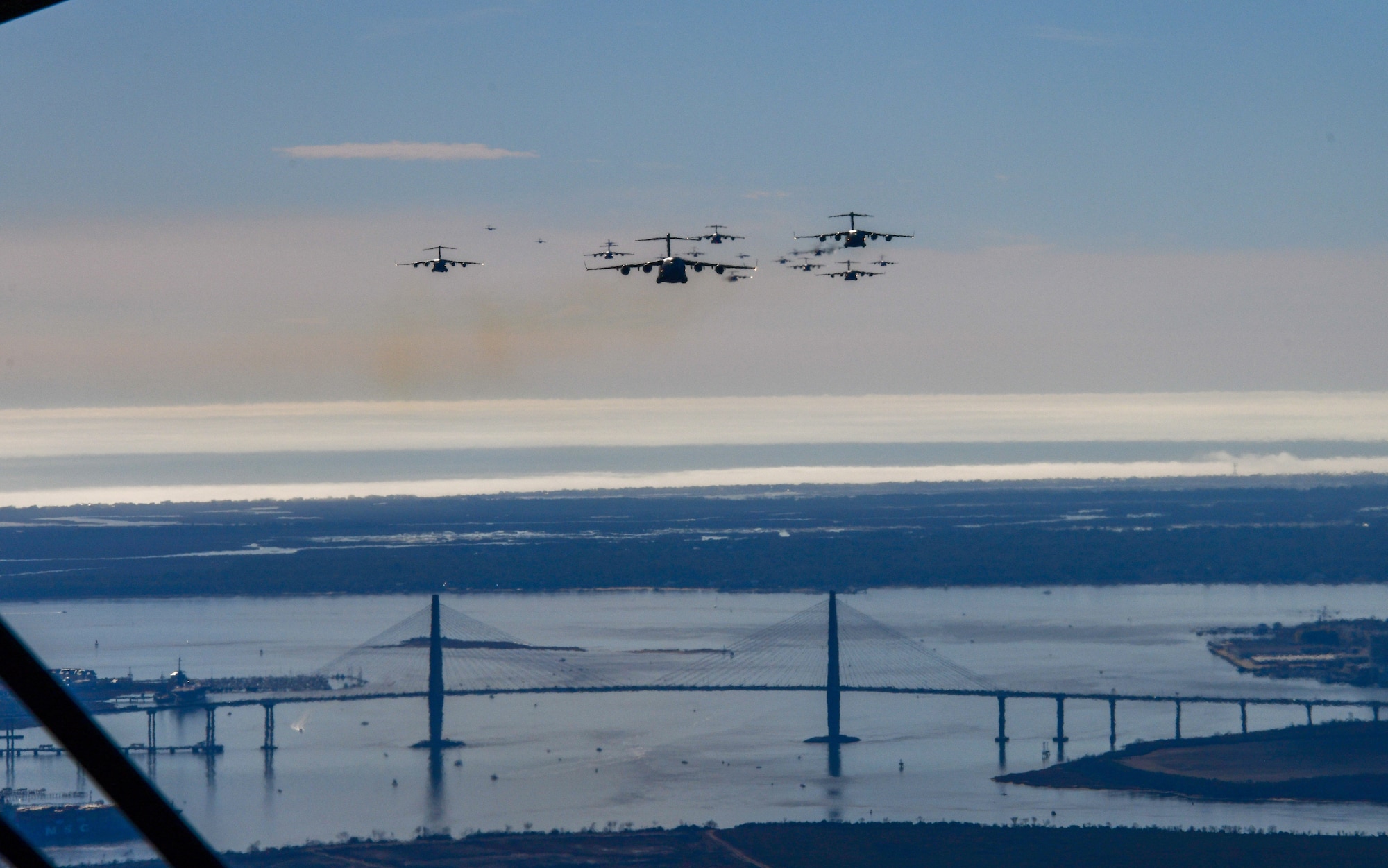 A photo of 24 Aircraft fly over a bridge.