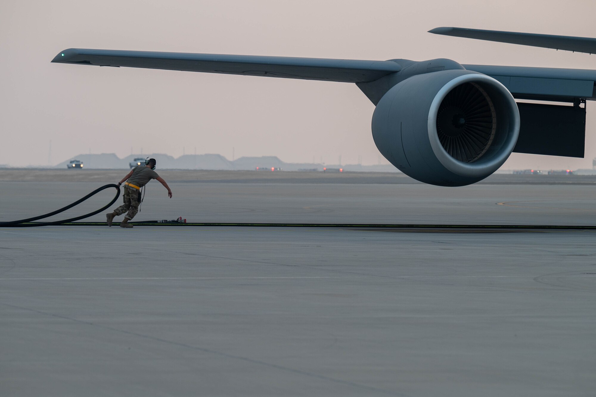 Tech. Sgt. Joseph Perez pulls a refueling hose after a ground aircraft-to-aircraft refuel at Al Udeid Air Base.