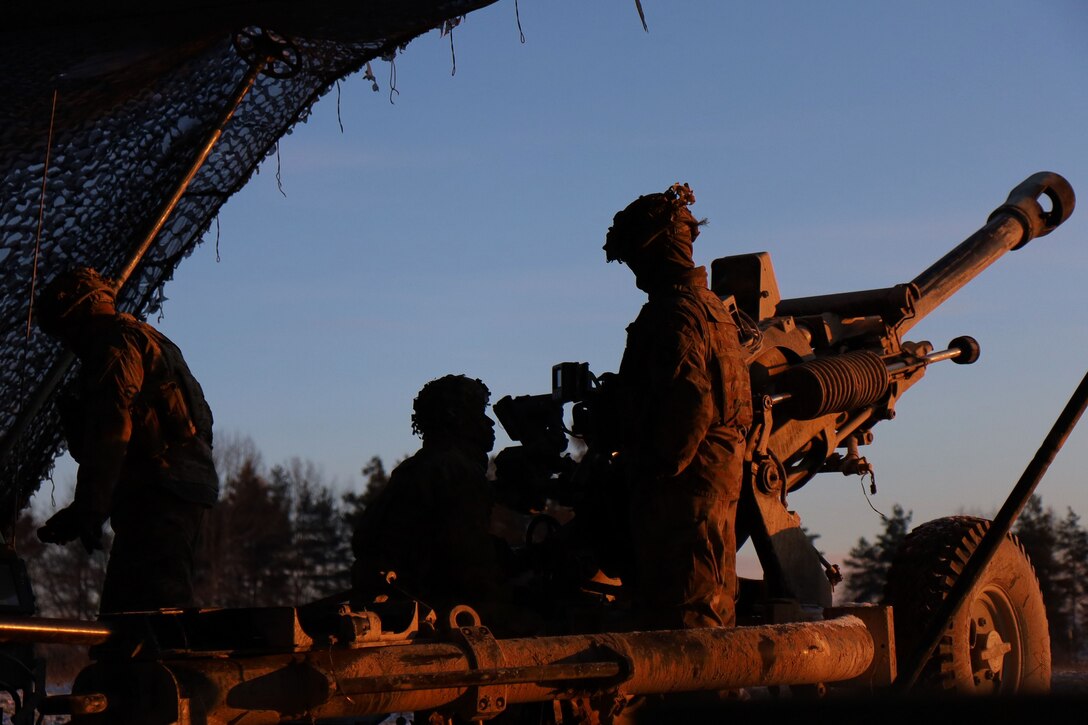 Soldiers fire a howitzer.