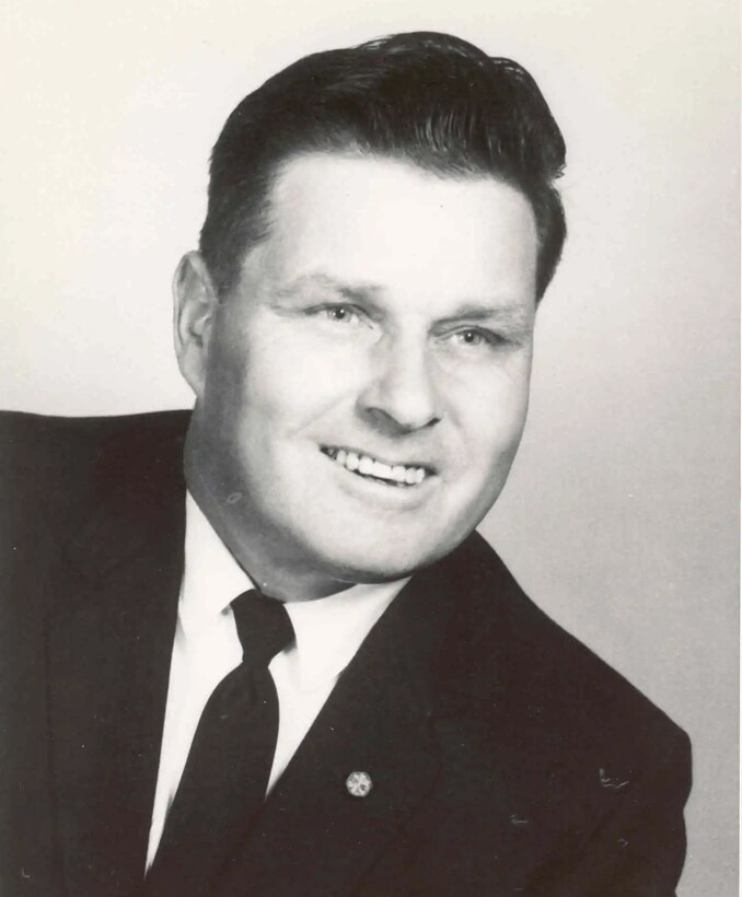A man in a suit smiles for the camera.