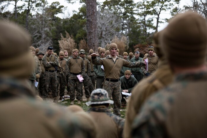 U.S. Marine Corps Capt. Kyle Kavanagh, Weapons Company, Commanding Officer, Battalion Landing Team 1/6, 26th Marine Expeditionary Unit, briefs personnel during a Rehearsal of Concept using a terrain model in preparation for a simulated raid during Marine Expeditionary Unit Exercise I at Marine Corps Auxiliary Landing Field Bogue, North Carolina, Dec. 20, 2022. The raid was the culminating MAGTF mission for the exercise. Through continued training and preparation, the 26th MEU will continue to be the nation’s premier expeditionary force-in readiness and remains ready and able to respond at a moment’s notice.