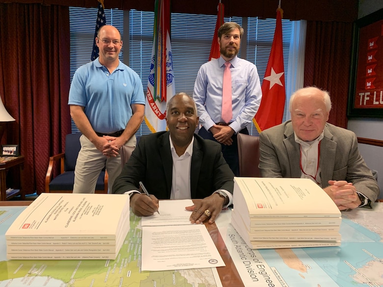 People sitting and standing at document signing.