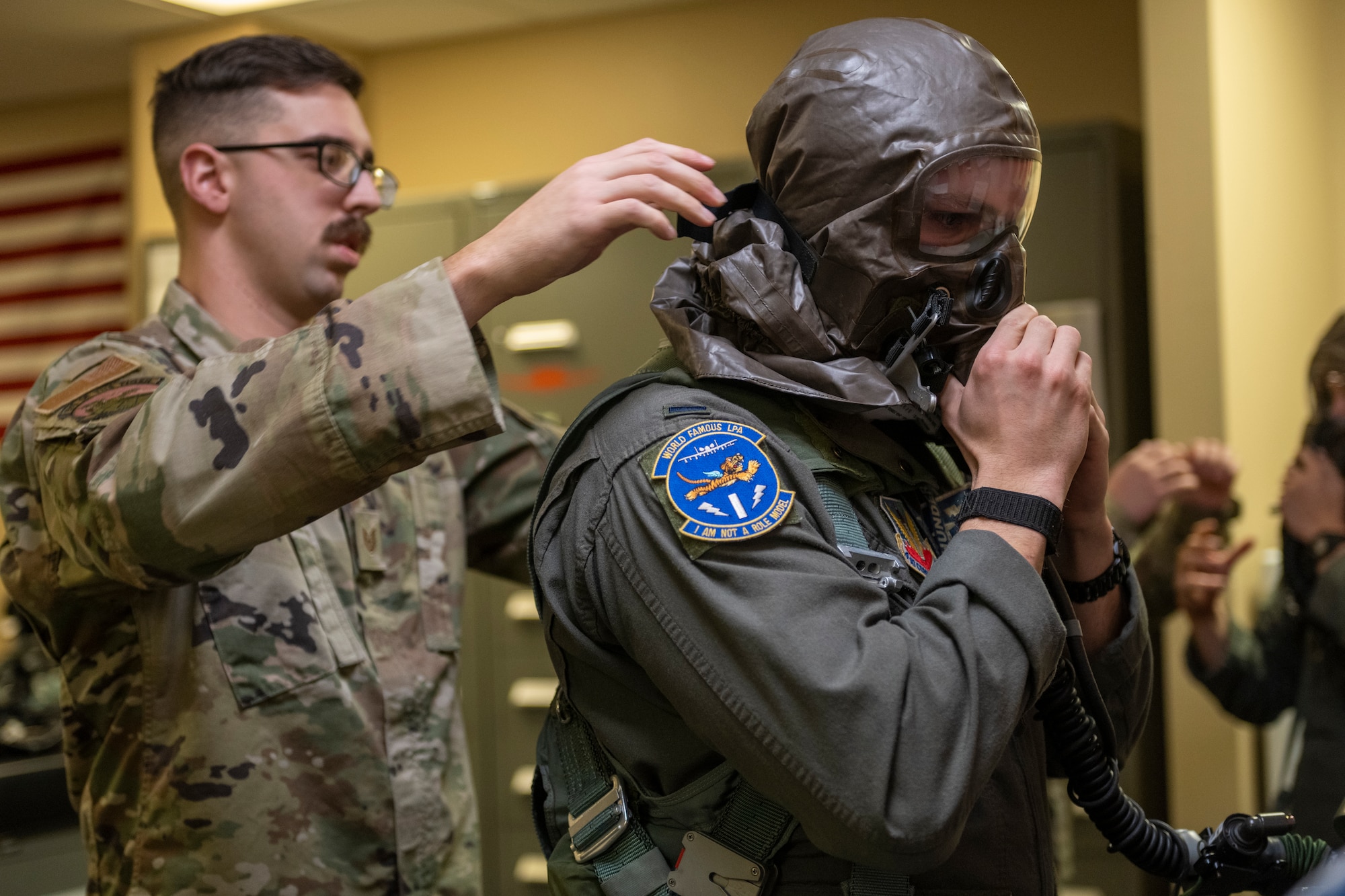 U.S. Air Force Tech. Sgt. Levi Schafer, 23rd Operation Support Squadron aircrew flight equipment inspection shop noncommissioned officer in charge, assists 1st Lt. James McMahon, 74th Fighter Squadron A-10C Thunderbolt II pilot, with his mask portion of an Aircrew Eye Respiratory Protection system at Moody Air Force Base, Georgia, Jan. 5, 2023.
