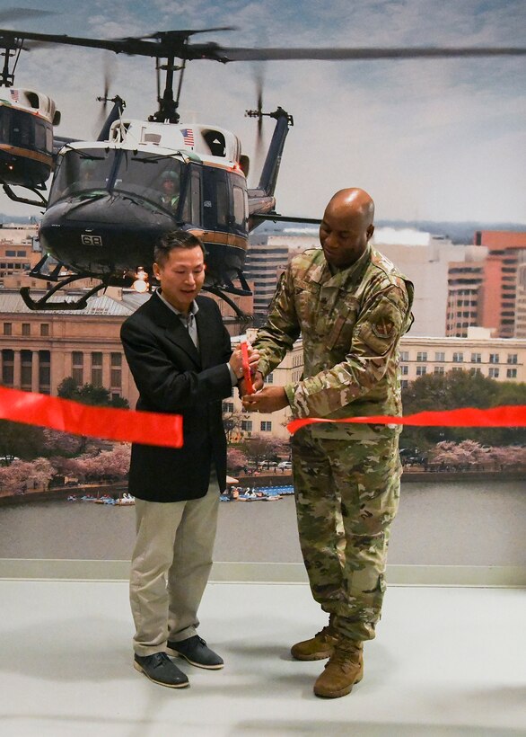 Col. Todd Randolph, right, 316th Wing and installation commander, cuts a ribbon with Dr. Thomas Bui, Human Performance Flight chiropractor, for the grand opening of a new chiropractic clinic at the 1st Helicopter Squadron at Joint Base Andrews, Md., Jan. 4, 2023.