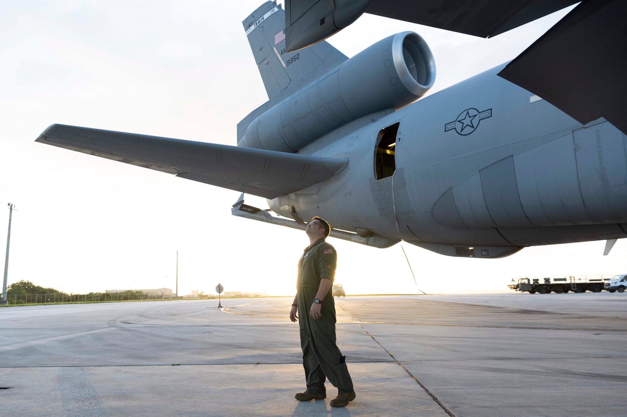 A military member looks at a large military aircraft.