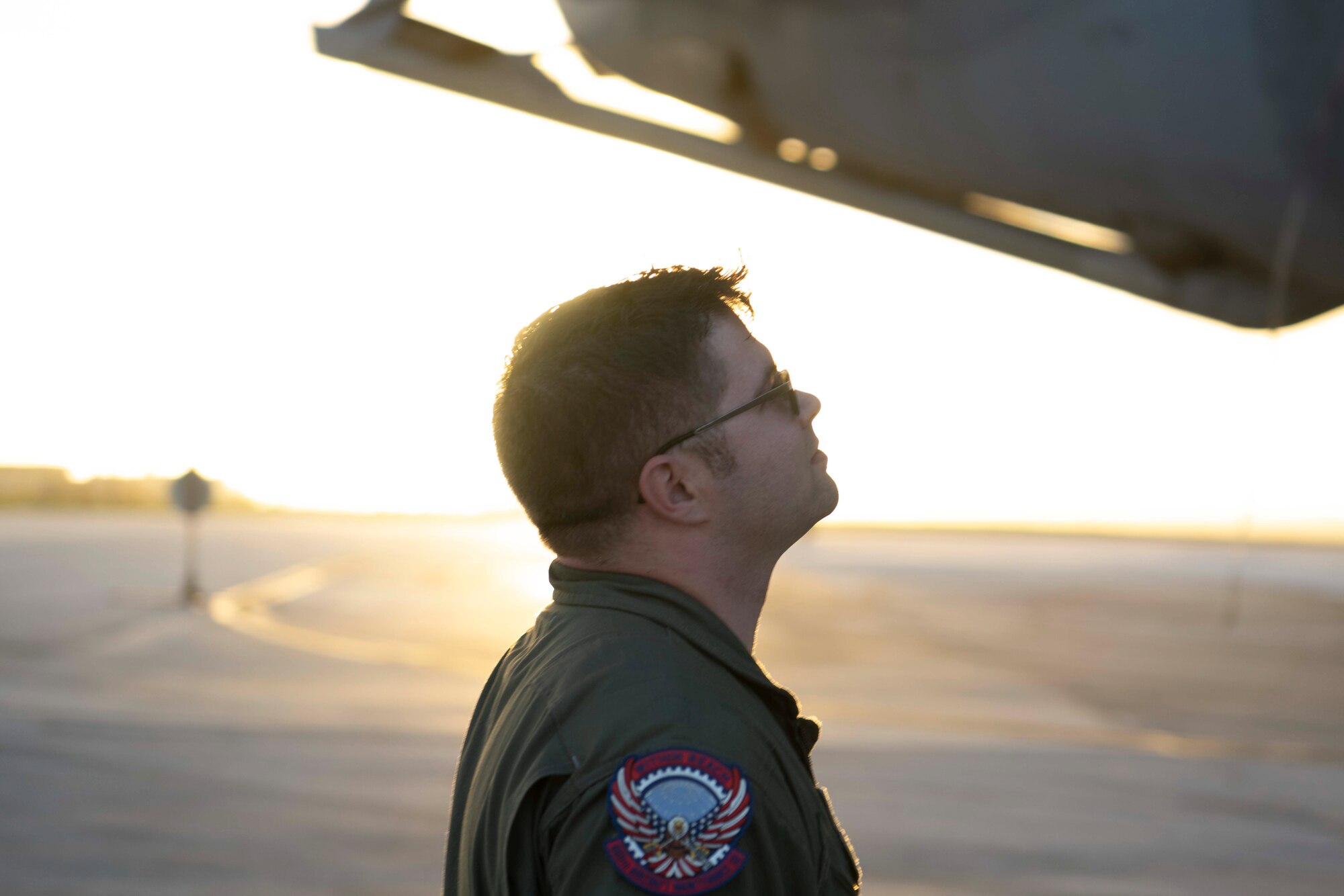 A military member looks at a large military aircraft.