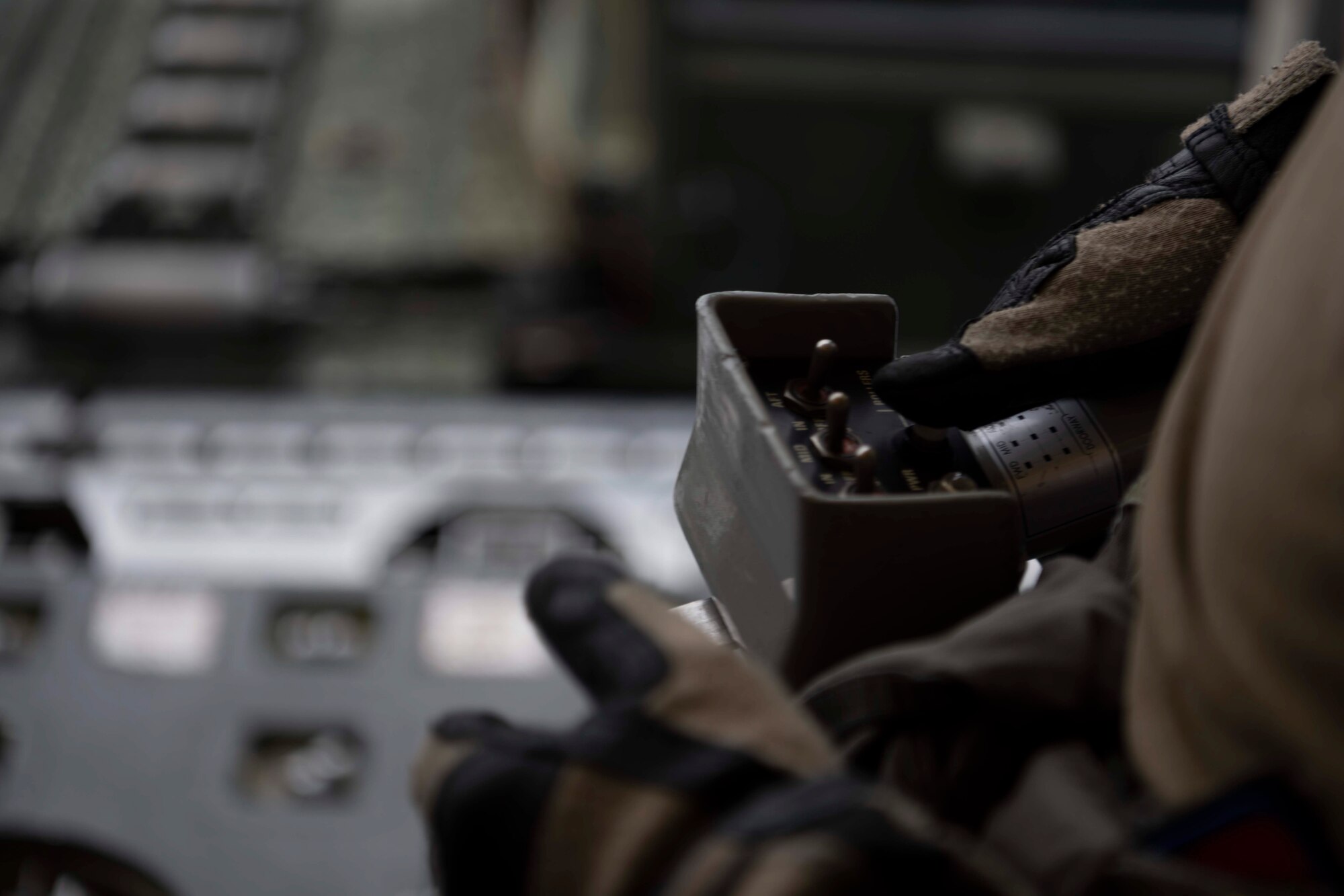 Hands of a man controlling a military device.