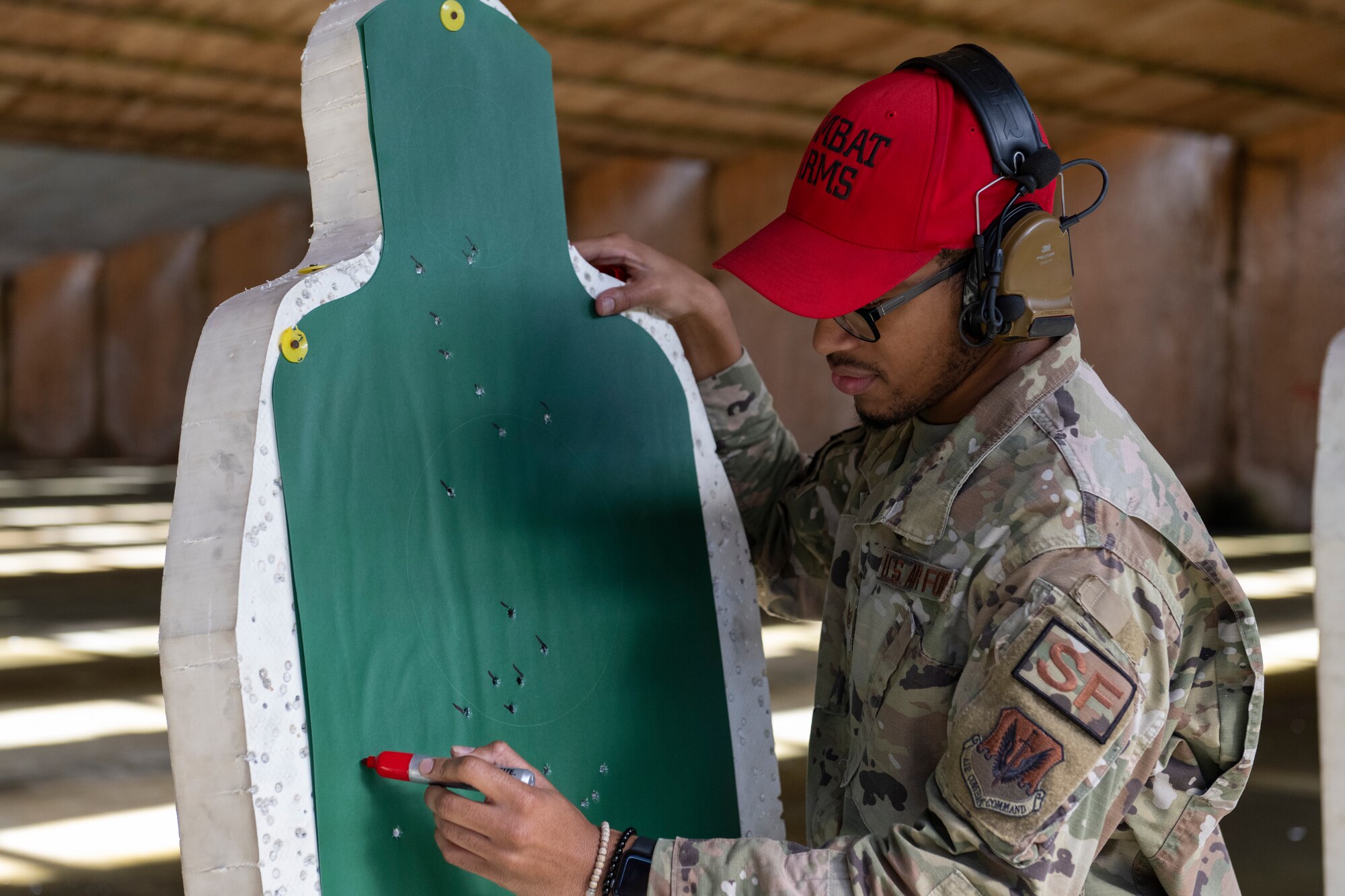 An Airmen counts bullet markings on a practice target.
