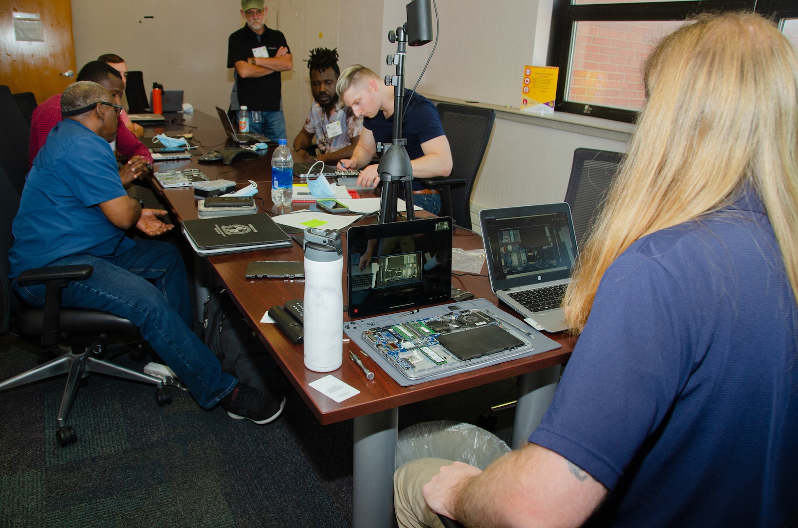 Chris Spearman, Information Technology Specialist at USMEPCOM, guides MEPS ITS personnel through immersion training by opening computers and replacing components.