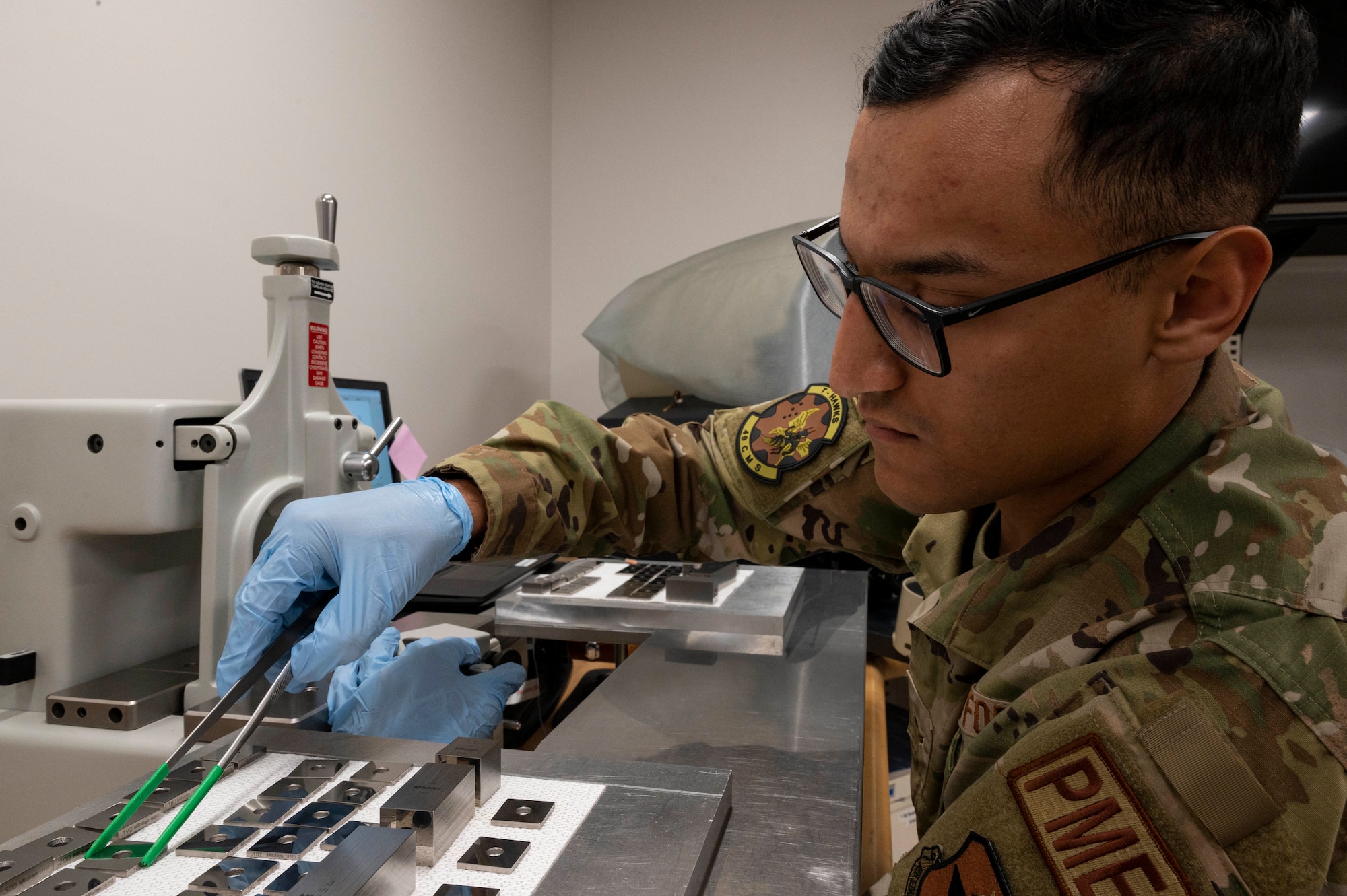 U.S. Air Force Airman 1st Class Gustavo Gaytan, 49th Component Maintenance Squadron physical dimensional technician, measures gauge blocks by using a gauge block comparator at Holloman Air Force Base, New Mexico, Jan. 6, 2023.