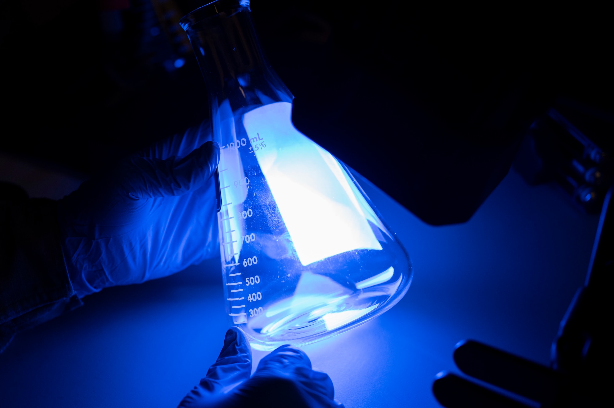 A beaker is set under a black light to check for oxygen contamination at Holloman Air Force Base, New Mexico, Jan. 6, 2023.