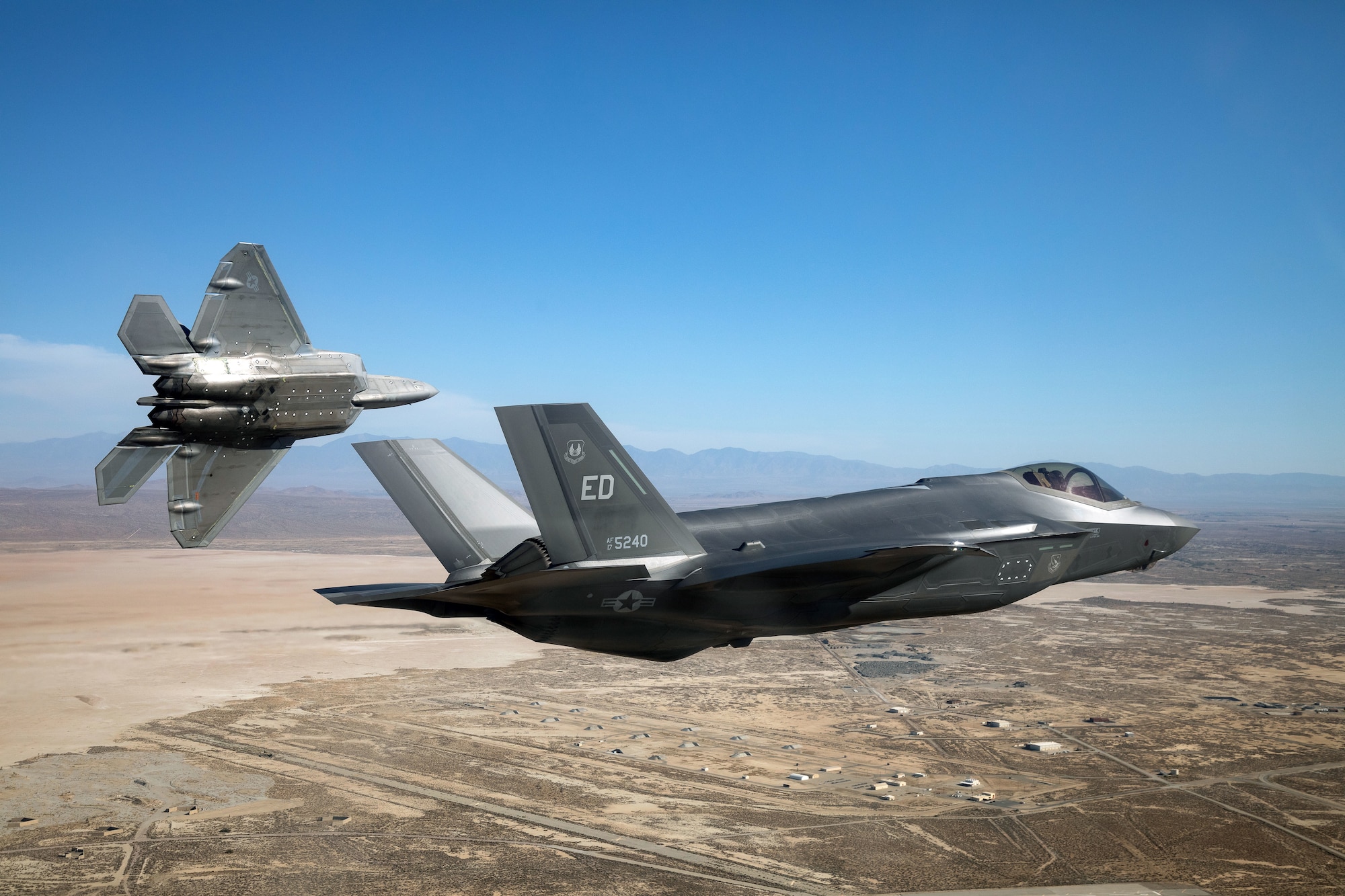 An F-22 Raptor from the 411th Flight Test Squadron and an F-35 Lightning II return to Edwards Air Force Base, California