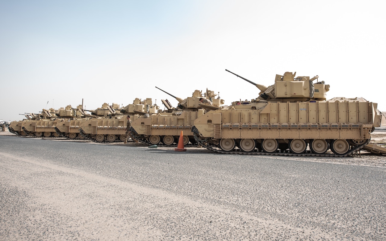 A group of military vehicles are parked in adjacent order.