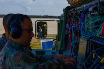 A photo of Airmen working on communications equipment.
