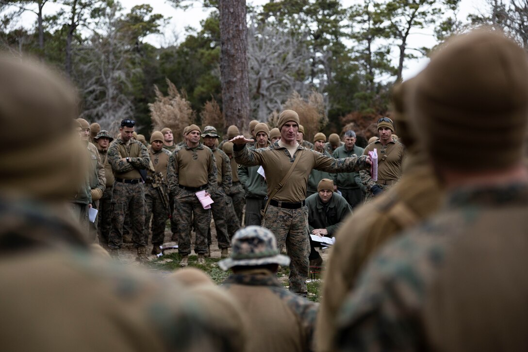 U.S. Marine Corps Capt. Kyle Kavanagh, Weapons Company, Commanding Officer, Battalion Landing Team 1/6, 26th Marine Expeditionary Unit, briefs personnel during a Rehearsal of Concept using a terrain model in preparation for a simulated raid during Marine Expeditionary Unit Exercise I at Marine Corps Auxiliary Landing Field Bogue, North Carolina, Dec. 20, 2022. The raid was the culminating MAGTF mission for the exercise. Through continued training and preparation, the 26th MEU will continue to be the nation’s premier expeditionary force-in readiness and remains ready and able to respond at a moment’s notice.