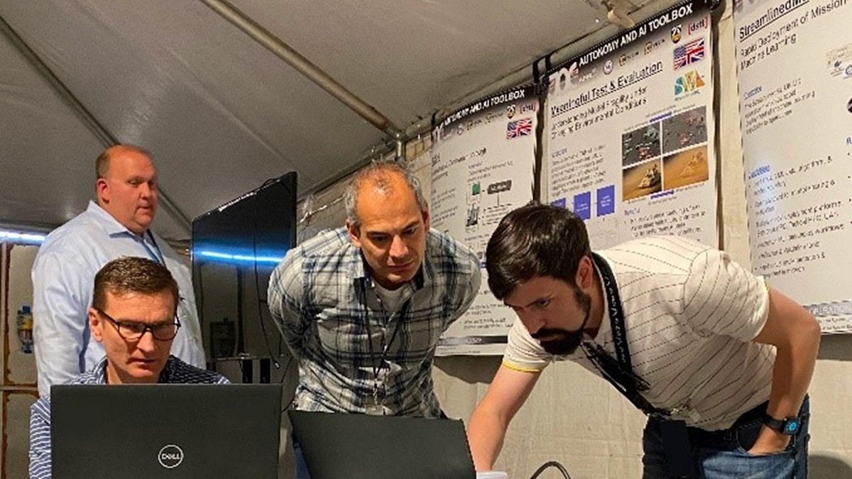 From left:  Patrick Fisher and Vladimir Omelko, members of the artificial intelligence, or AI, taskforce from the Air Force Research Laboratory, or AFRL, examine AI models with Dr. Nicholas del Rio and Harry Hartenstine at the U.S. National Training Centre in Fort Irwin, California, Nov. 4, 2022. AFRL, in partnership with the U.K.’s Defence Science and Technology Laboratory, demonstrated state-of-the-art technology at two military exercises in November and December 2022 as part of a joint U.K-U.S. collaboration on autonomy and AI. (U.S. Air Force photo).