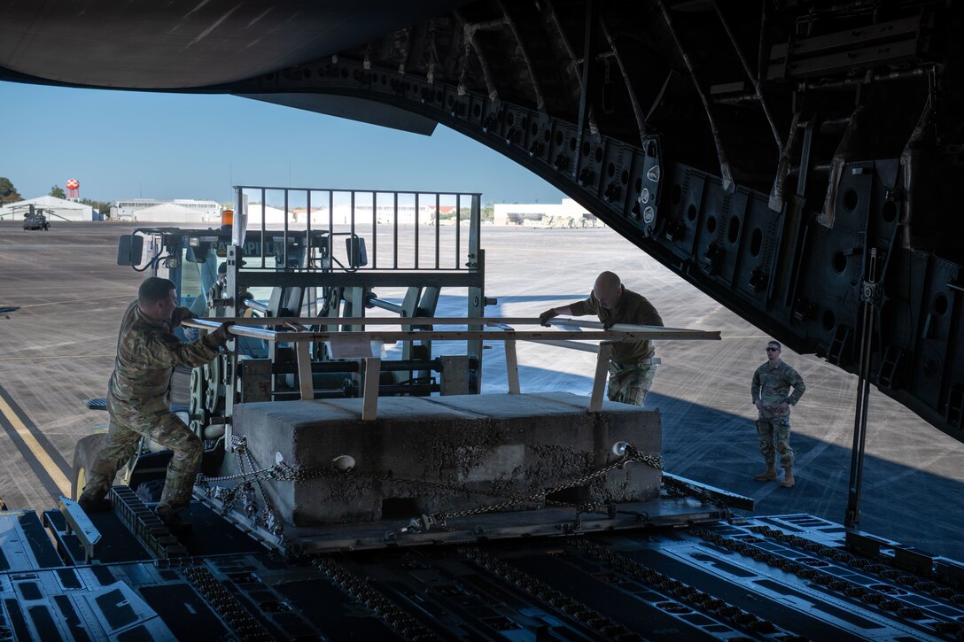 A photo of Airmen loading a pallet onto an aircraft.