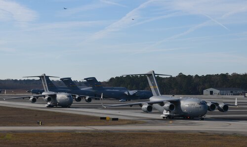 A photo of two aircraft driving down the flightline.