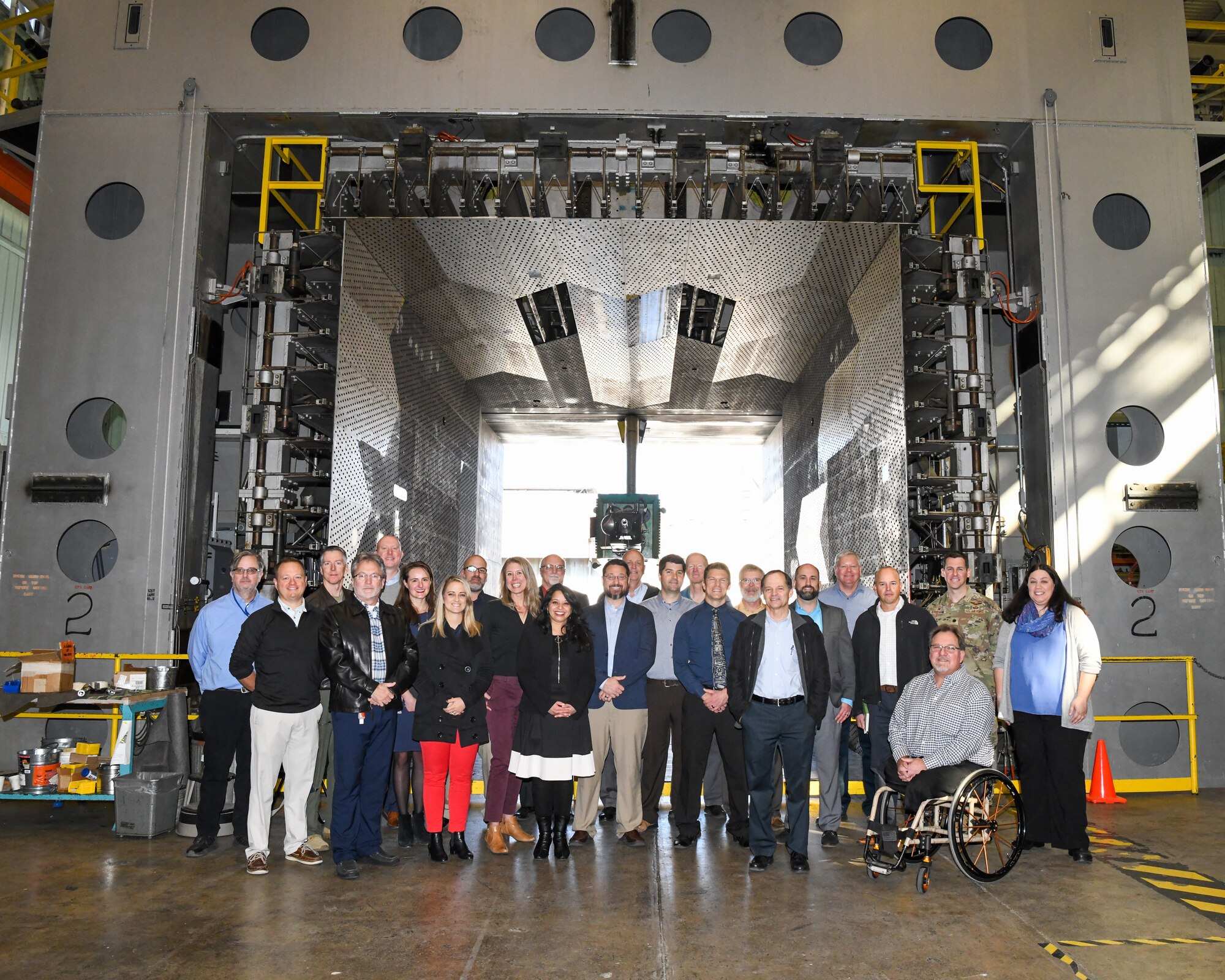 Air Force Test Center technical leaders pose for a photo in front of one of the test carts used in the Propulsion Wind Tunnel Facility at Arnold Air Force Base, Tennessee.
