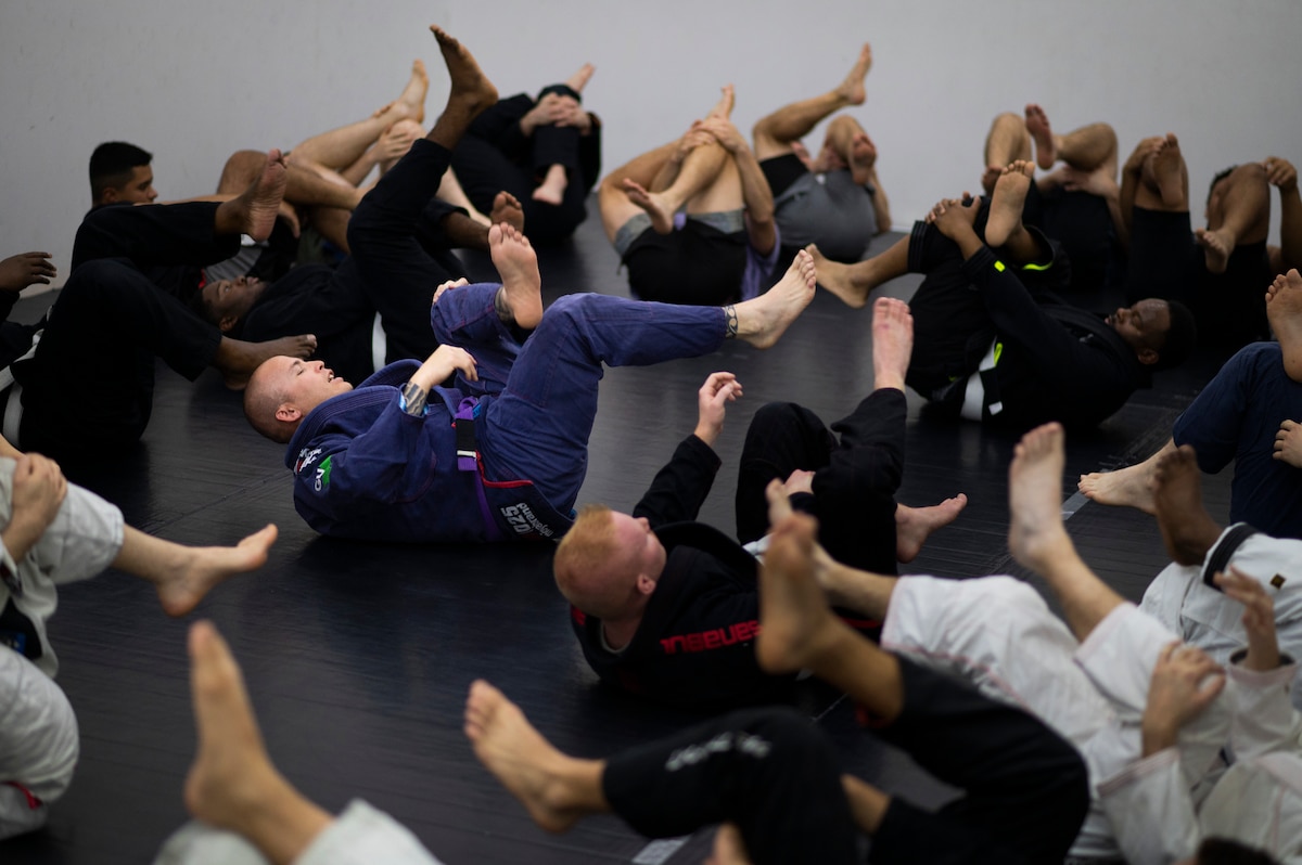 From center, Tech. Sgt. Justin Leon Guerrero, 386th Expeditionary Security Forces Squadron military working dog trainer and Jiu-Jitsu team coach, leads the team during warm-ups prior to Jiu-Jitsu practice at Ali Al Salem Air Base, Kuwait, Dec. 30, 2022. The Jiu-Jitsu team has seen an increase in participants after competing in a multi-national Kuwait grappling tournament on Dec. 9, 2022. (U.S. Air Force photo by Staff Sgt. Dalton Williams)