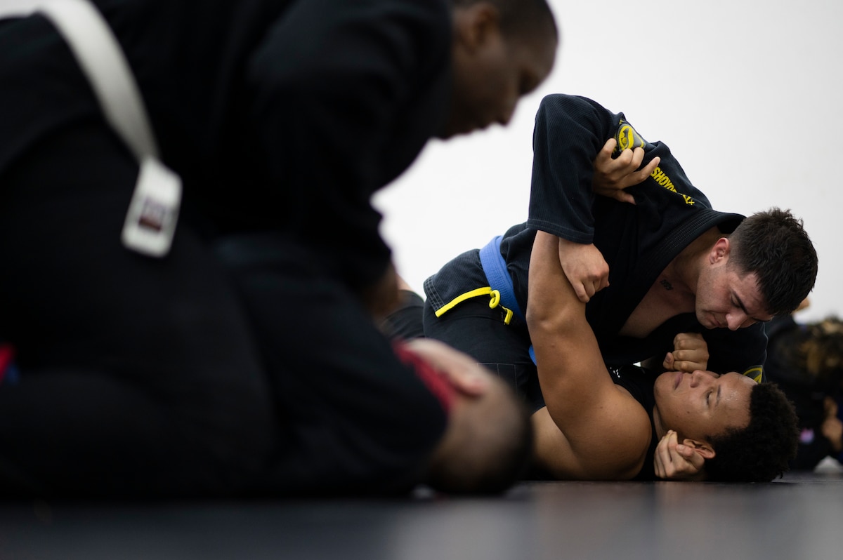 Staff Sgt. Luis Osuna-Zatarain, 386th Expeditionary Logistics Readiness Squadron traffic management office passenger travel supervisor, grapples with Airman 1st Class Tyler Laundry, 386th Expeditionary Security Forces Squadron patrolman, during Jiu-Jitsu practice at Ali Al Salem Air Base, Kuwait, Dec. 30, 2022. Athletes often practice and compete in a Gi, a traditional loose uniform for practice and competition. (U.S. Air Force photo by Staff Sgt. Dalton Williams)