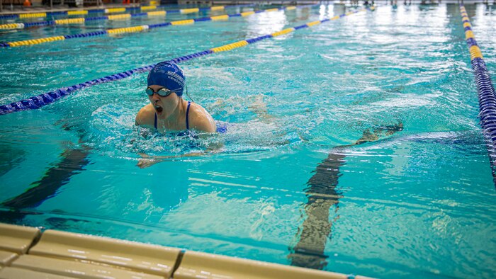 A woman takes a breathe while swimming.