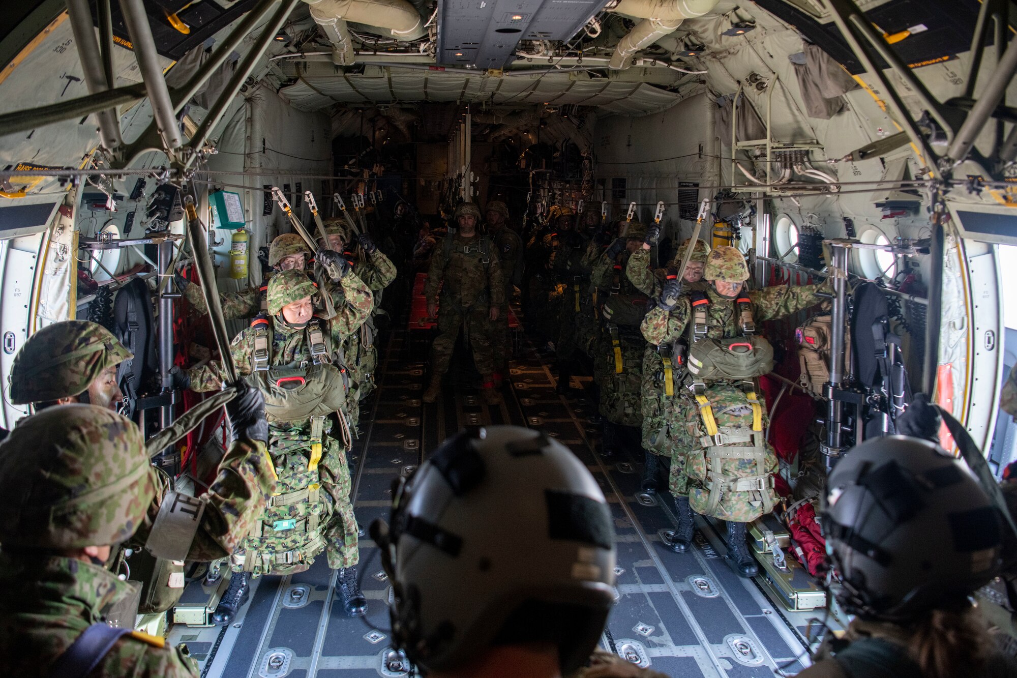 Paratroopers hook up to the static line inside of a C-130J