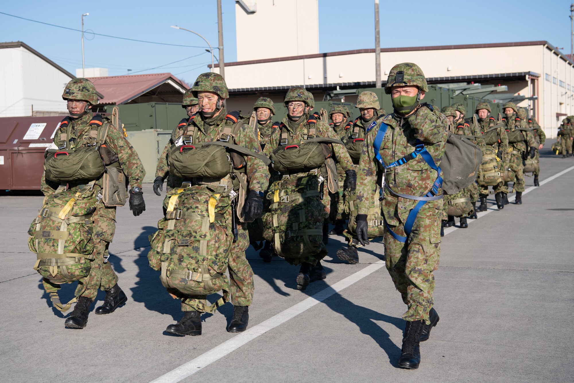 Paratroopers walk on a flightline