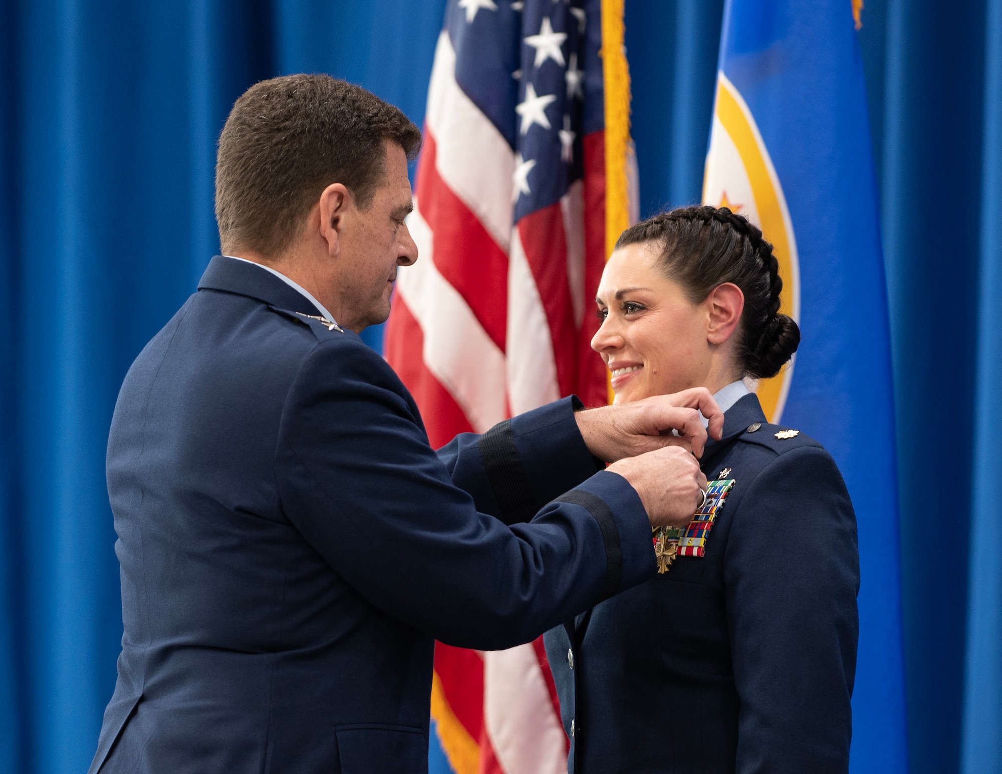 U.S. Air Force Lt. Gen. Michael A. Loh, Director of the Air National Guard, fastens the Distinguished Flying Cross onto Maj. Katie Lunning’s uniform in St. Paul, Minn., Jan. 7, 2023.