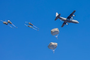 Paratroopers stand under the static line on a C-130J