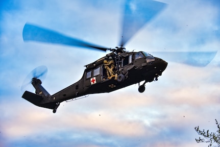 A Black Hawk from the 1-230th Assault Helicopter Battalion of the Tennessee National Guard hovers while medics prepare to descend during the SAREX 23 exercise in Pickett State Park near Jamestown, Tenn., Jan. 7, 2023. The group worked on tracking, locating and evacuating missing people as part of a training exercise with other military and civilian agencies to strengthen partnerships in a joint environment.