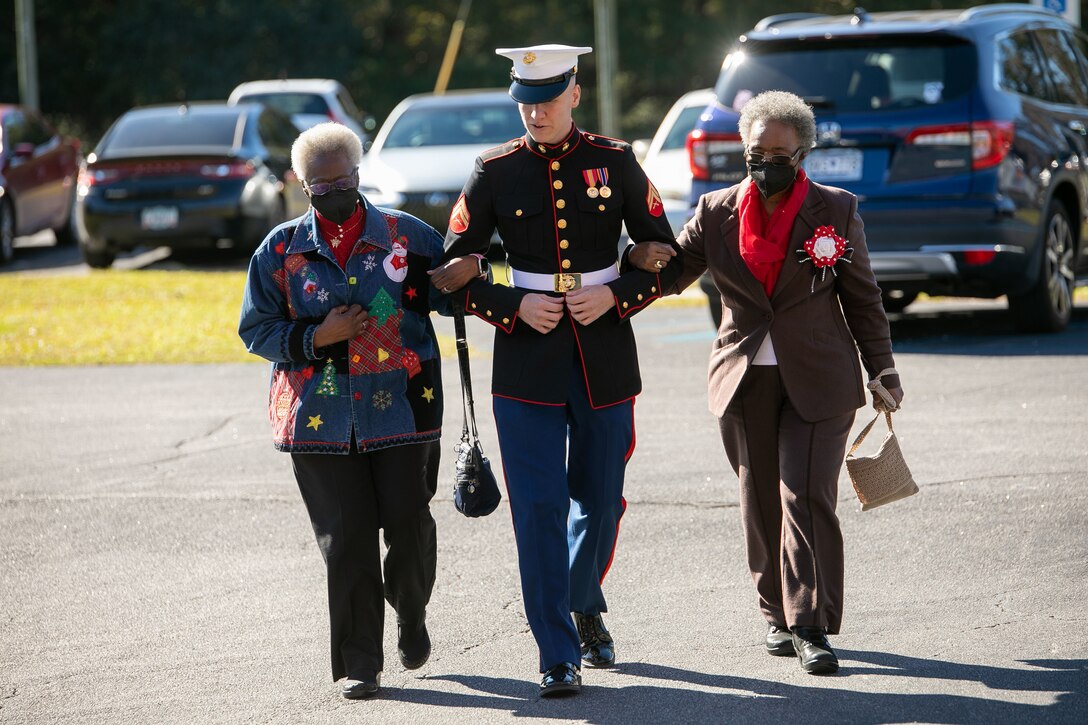U.S Marine Corps Cpl. Jadon Ward, engineer equipment manager, Marine Wing Support Squadron 273, Marine Aircraft Group 31, escorts guests to the Officers’ Club during the 51st Senior Citizen Tea at Marine Corps Air Station (MCAS) Beaufort, South Carolina, Dec. 19, 2022. MCAS Beaufort partnered with the Beaufort Military Spouses’ Club to host the event allowing military families the opportunity to give back to the community for their continued support. (U.S. Marine Corps photo by Cpl. Hernan Rodriguez)