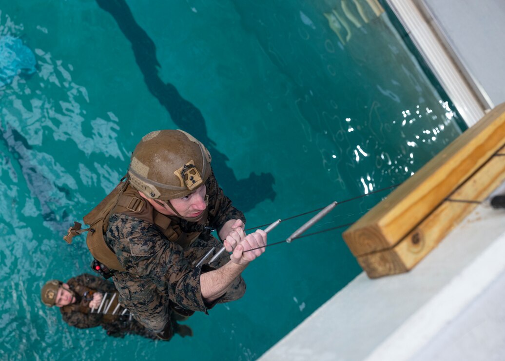 A U.S. Marine with Battalion Landing Team 1/6, 26th Marine Expeditionary Unit, climbs a cable ladder during a Visit, Board, Search, and Seizure course at Marine Corps Base Camp Lejeune, North Carolina, Jan. 6, 2023. The VBSS course is designed to train the Maritime Special Purpose Force and supporting enablers of the Amphibious Ready Group/MEU to conduct Maritime Interception Operations. (U.S. Marine Corps photo by Cpl. Matthew Romonoyske-Bean)
