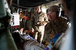 From left, U.S. Air Force Lt. Col. Trina Young, a flight nurse assigned to the 167th Aeromedical Evacuation Squadron based at McLaughlin Air National Guard Base, Charleston, West Virginia, holds medical equipment, while flight medics Airman 1st Class Caleb Wynne and Airman 1st Class Haleigh Romage attempt to resuscitate a simulated dying patient during a medical evacuation exercise aboard a C-130J, Dec. 20, 2022. The 167th AES conducted in-flight emergency medical simulation training to maintain currency and hone their medical skills for real-world missions. (U.S. Air National Guard photo by Airman 1st Class Kaden Salmons)