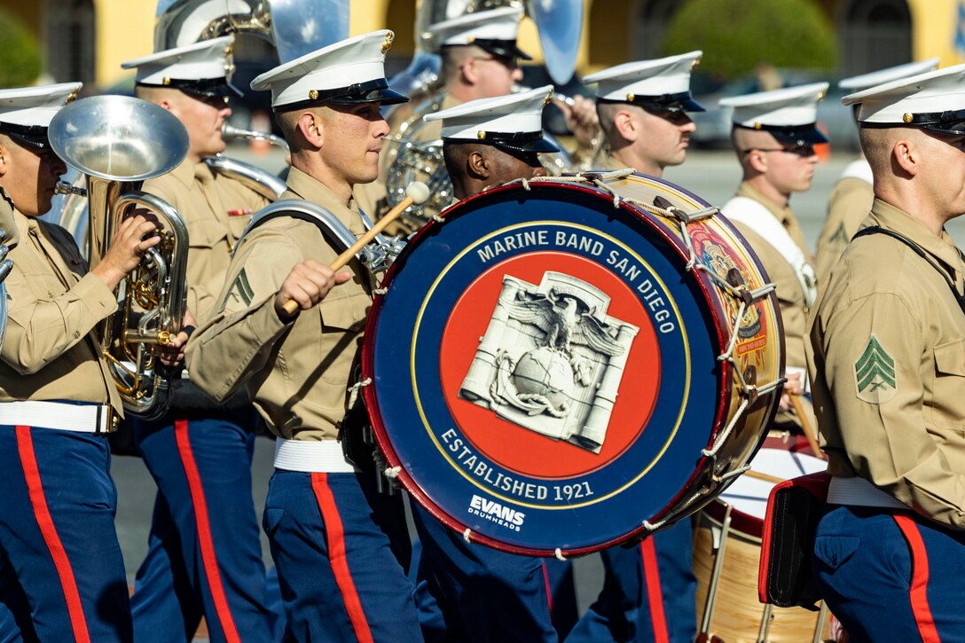 Members of the Marine Corps band play instruments while walking.