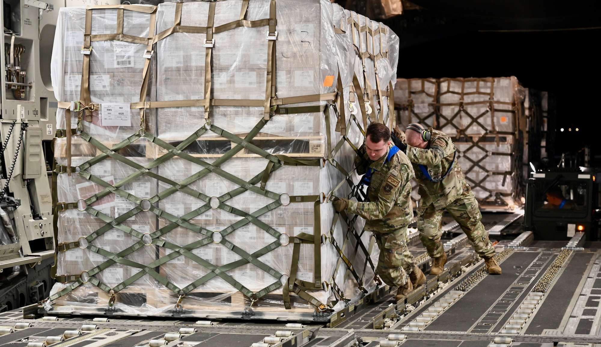 U.S. Air Force Airmen assigned to the 721st Aerial Port Squadron push a pallet of infant formula onto a C-17 Globemaster III at Ramstein Air Base, Germany, May 22, 2022.