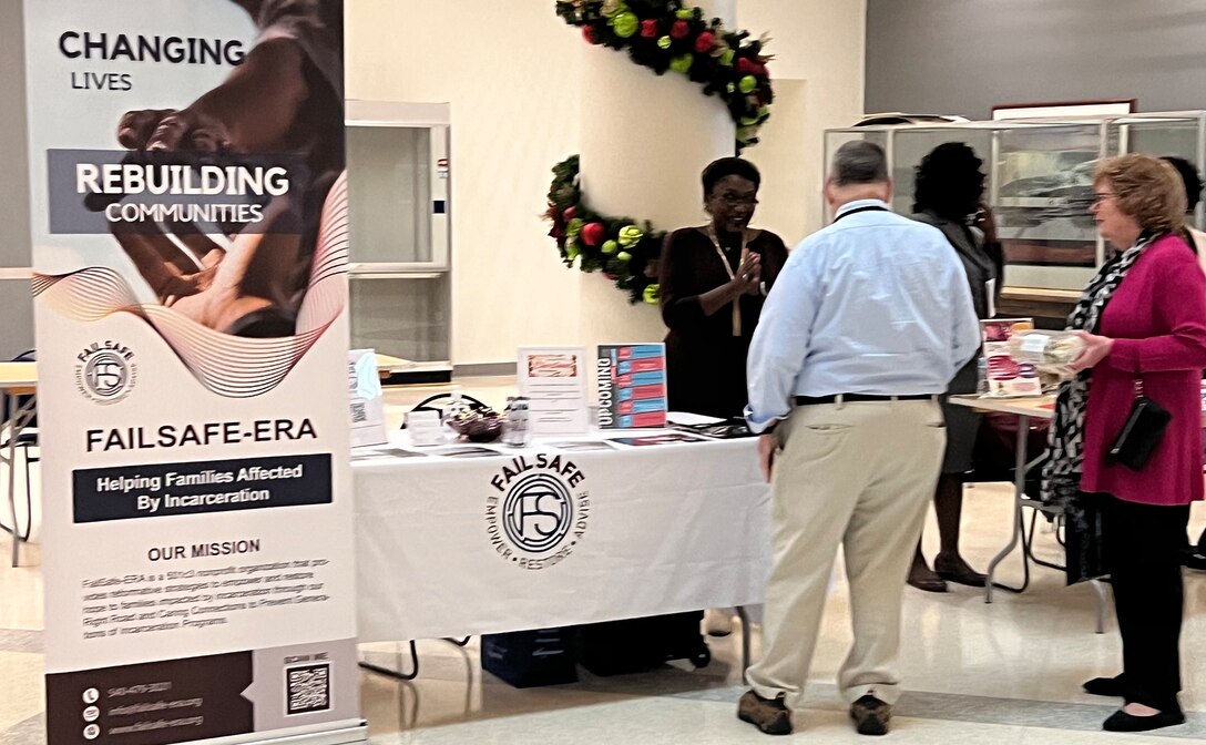 People stand at a display table with posters