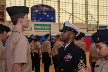 A U.S. Navy Senior Chief inspects a Navy Junior Reserve Officer Training Corps (NJROTC) cadet.