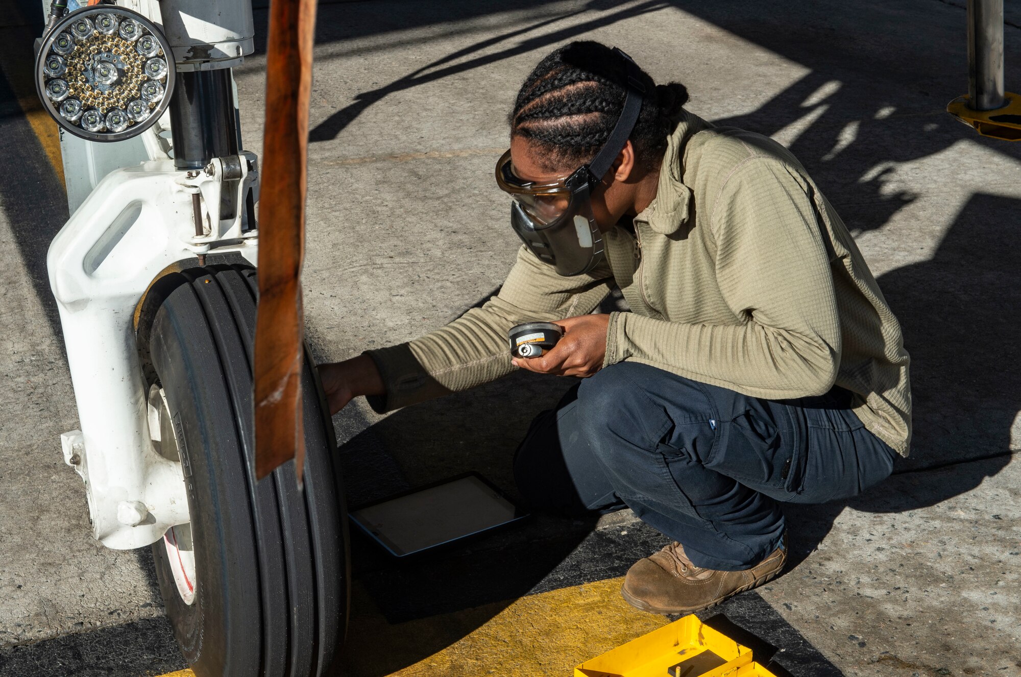 woman checking aircraft tire pressure