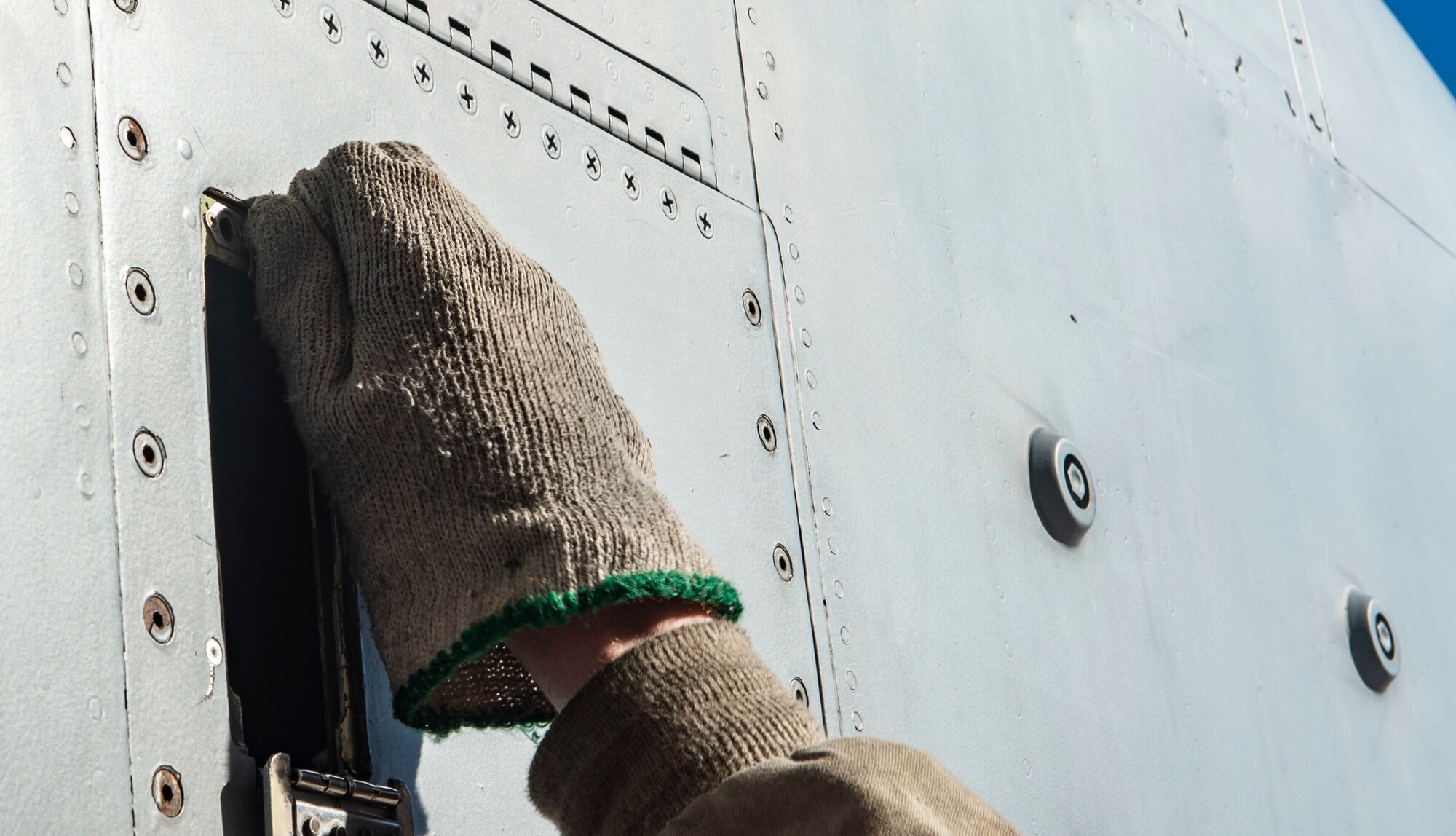 hand unscrewing a plane panel