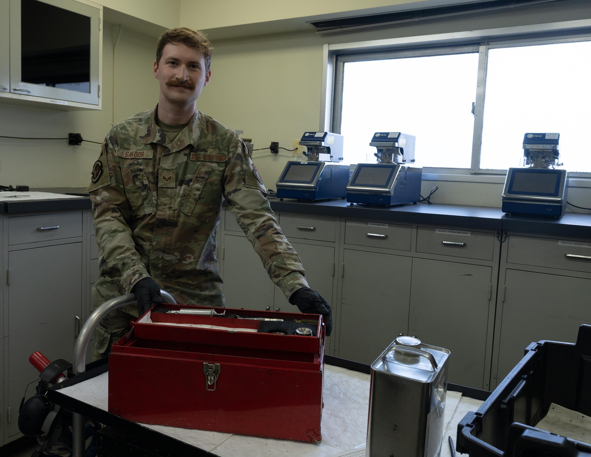 An Airman poses for a picture while holding fuels equipment.