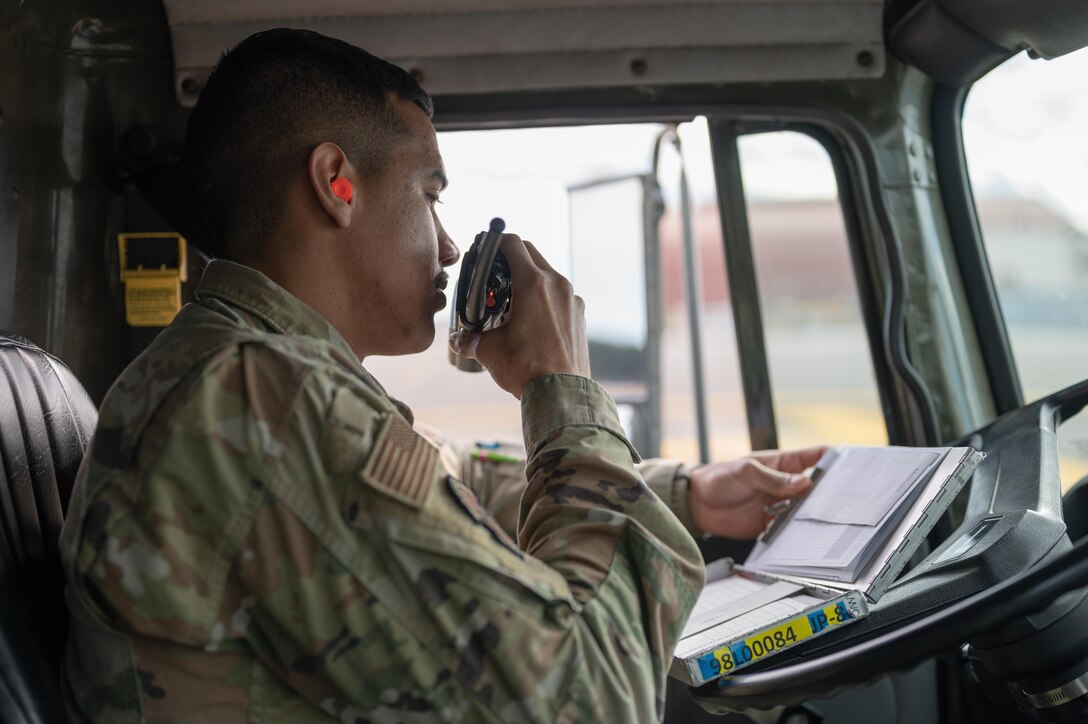 U.S. Air Force Airman 1st Class Juan Ortiz, radios in to his team for information on refueling at Yokota Air Base